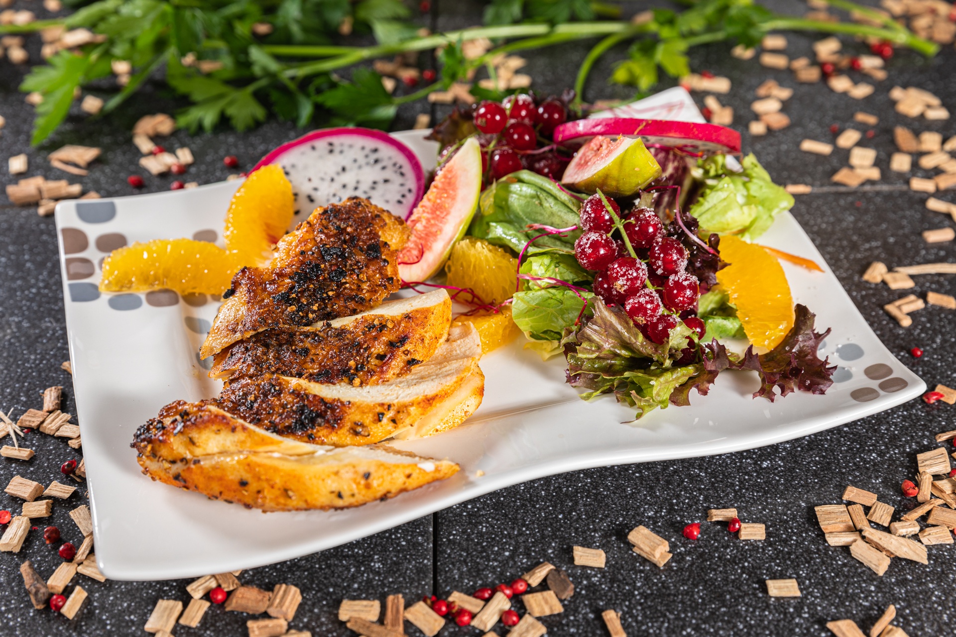 Mit Pfeffer-Himbeerrub eingestrichene Hähnchenbrust an frischem Blattsalat-Früchtereigen